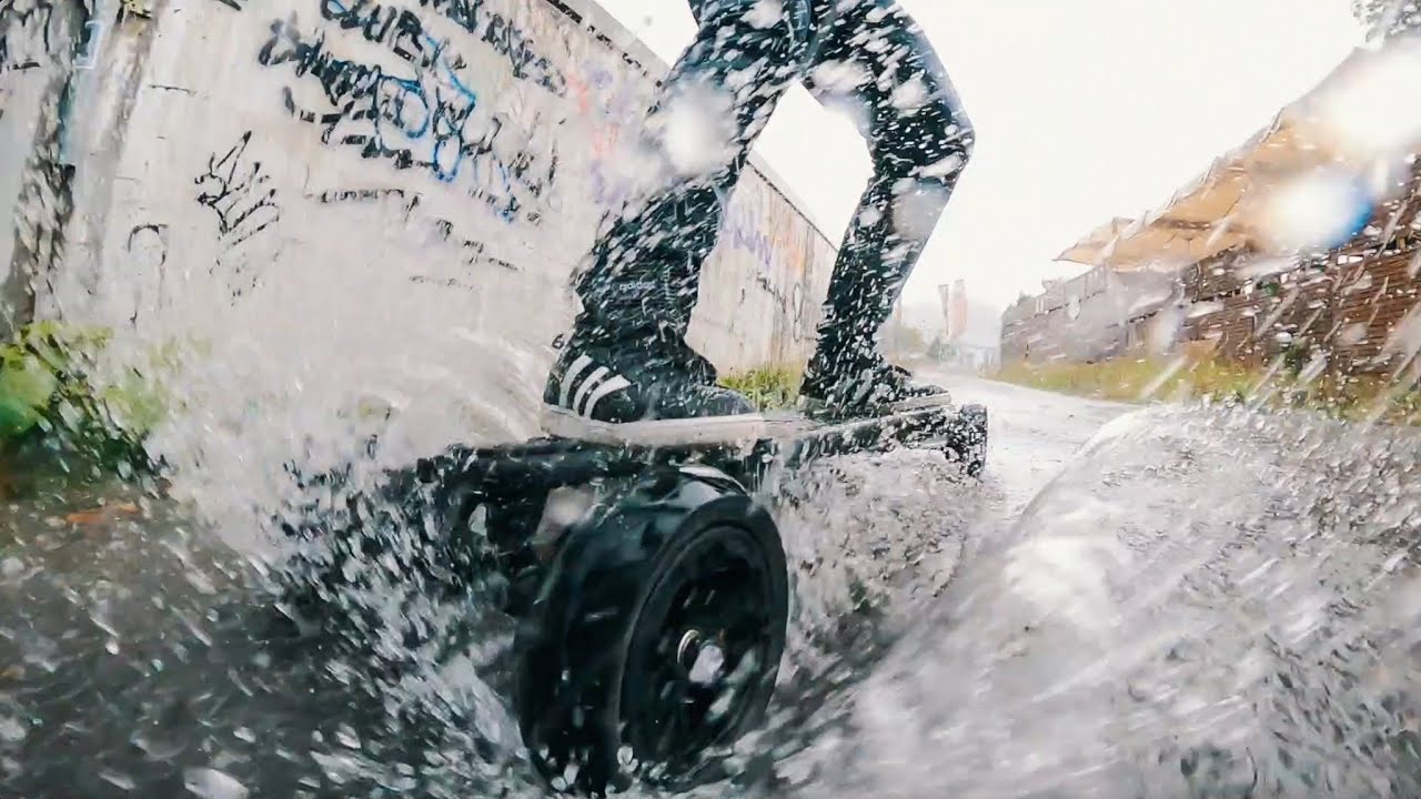 ONSRA VELAR Elektro-Skateboard auf nasser Schweizer Strasse – spritzwassergeschützt nach IP65.